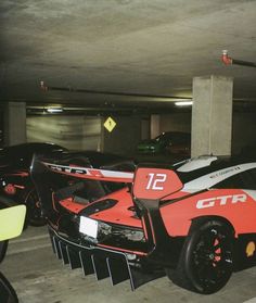 several race cars parked in a parking garage with no one around them or on the ground