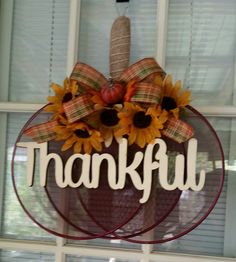 a sunflower wreath with the word grateful hanging on a door