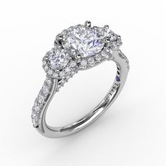 a three stone engagement ring with an oval center surrounded by round diamonds