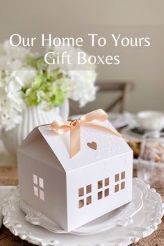 A pretty house shape box with cut outs for windows and hearts and tied with a satin ribbon on the roof sits atop a small stack of white plates. Dessert Fancy, Small Cake Boxes, Christmas Cookies Packaging, Gift Box Cakes, Dessert Box, Cookies Branding, Cookie Gift Box, Tooth Fairy Box, Cookie Boxes