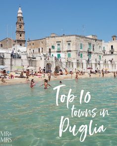 people are swimming in the water near an old building with white lettering that reads top 10 towns in pugliia