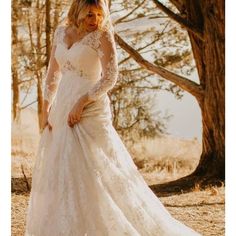 a woman in a wedding dress is posing for the camera with her hands on her hips