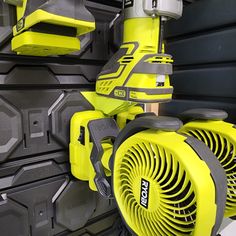 a yellow fan sitting on top of a wall next to some gray and black walls