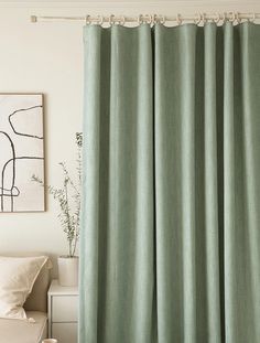 a living room with a couch, chair and green curtain in front of the window