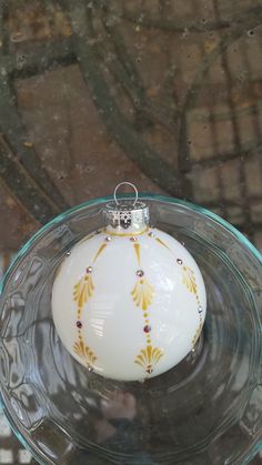 an ornament is sitting on top of a glass plate in the shape of a ball