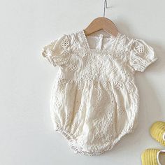 Introducing our adorable Ruffle Strap Baby Jumpsuit, a timeless and versatile piece that every new mom and baby will love. This jumpsuit combines style and practicality, ensuring both comfort and convenience for your little one. Featuring charming ruffled details at the shoulders and a gathered skirt, this jumpsuit exudes cuteness and adds a playful touch to your baby's wardrobe. The clever design creates the illusion of a two-piece outfit, with the jersey bodysuit seamlessly attached to the dre Spring Playtime Bodysuit, Cotton Ruffle Onesie With Short Sleeves, Cotton Onesie With Ruffles And Short Sleeves, Cotton Short Sleeve Onesie With Ruffles, Cotton Bubble Romper With Short Sleeves For Baptism, Cute Bodysuit For Spring, Spring Beige Cotton Bodysuit, Solid Cotton Bodysuit With Ruffles, Beige Cotton Spring Bodysuit