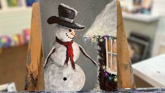 an easel with a snowman painted on it