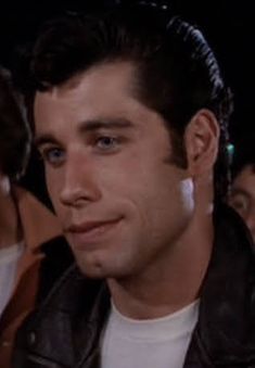 a close up of a person wearing a leather jacket and looking at something in the distance