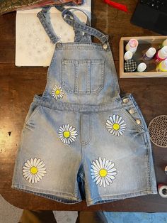 Hand painted daisies on dungaree jean shorts. Fun and floral design ready for the good weather. Painted Daisies, Painted Daisy, Ray Ray, Denim Dungaree, Daisy Painting, Womens Jumpsuits, Flower Shorts, Dungaree Jeans, Floral Denim