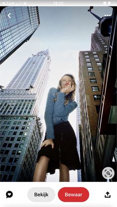 a woman standing in the middle of tall buildings with her hands on her hips and looking up