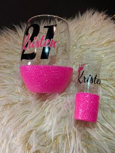 two wine glasses with pink glitter and the number twenty one is next to each other