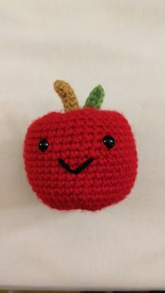 a crocheted apple with a smiling face