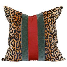 a leopard print pillow with red, green and blue stripes on the front side that has an orange stripe down the middle