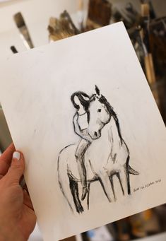 a drawing of a horse and its foal is being held by a person