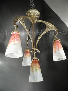 a chandelier with three lights hanging from it's sides and an ornate design