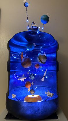 a blue display case with planets and stars on it's sides, in front of a wall