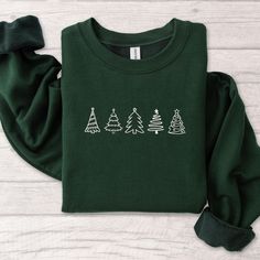 Christmas Tree Embroidered Sweatshirt, Christmas Tshirt Hoodie Embroidered , Christmas Embroidery Sweatshirt, Christmas Gift, MADE IN USA There are two brands we use: Gildan and our own brand BeePro Handmade. Comfort Colors, Bella Canvas, and other brands are available upon request at a different price. If interested in adding embroidery to the sleeve please go to this listing: https://www.etsy.com/listing/1674502020 Because it is made to order, we don't accept the return or exchange unless we m Green Embroidered Tops For Winter, Casual Embroidered Christmas Top, Holiday Embroidered Casual Sweatshirt, Casual Embroidered Holiday Sweatshirt, Casual Holiday Embroidered Sweatshirt, Christmas Long Sleeve Cotton Hoodie, Festive Long Sleeve Cotton Sweater, Embroidered Cotton Christmas Sweatshirt, Casual Christmas Sweater With Embroidery