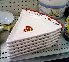 a stack of pizza plates sitting on top of a shelf next to other dishes and cups