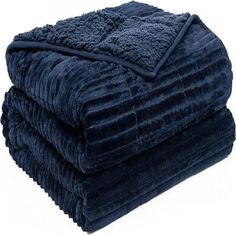 three blankets stacked on top of each other in different colors and sizes, one blue