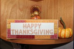 a happy thanksgiving sign sitting on top of a wooden shelf