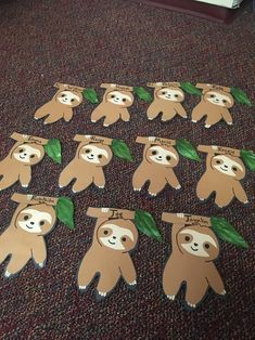 some paper cut out animals with green leaves on them sitting on the floor in front of a door