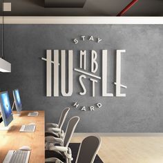 an office with multiple computers and chairs in front of a wall that says stay humble hard