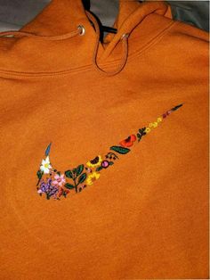 an orange hoodie with colorful flowers on it