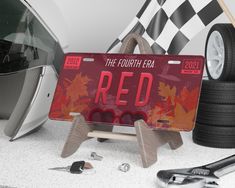 a red license plate sitting on top of a table next to tools and other items