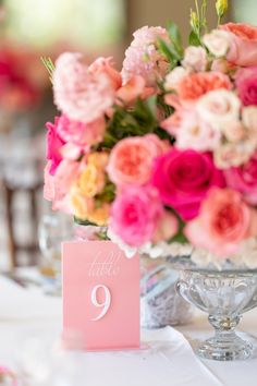 there is a vase with flowers on it and a table number in front of it