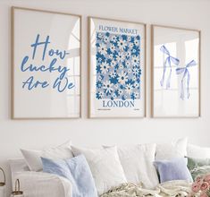 three blue and white posters hang on the wall above a couch in a living room