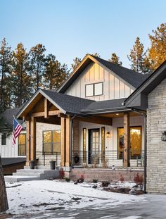 a house that is in the snow with an american flag hanging from it's front door