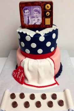 a cake decorated with chocolate candies and a photo on top is sitting next to a cookie sheet