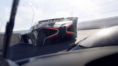 a futuristic race car driving down the road