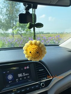 a stuffed animal hanging from the dashboard of a car