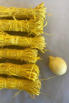 several bundles of yellow grass next to a lemon