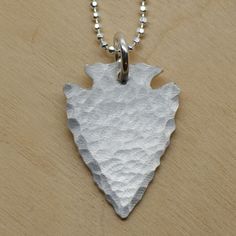 "Inspired by a recent trip to central Utah where I found an arrowhead in the wild, this necklace features a thick piece of sterling silver that's hand cut and hammered to re-create the iconic arrowhead look. Arrowhead measures approximately 1\" x 3/4\"." Handmade Sterling Silver Arrowhead Necklace, Silver Sterling Silver Arrowhead Necklace, Silver Adjustable Arrowhead Necklace, Adjustable Silver Arrowhead Necklace, Silver Sterling Arrow-shaped Jewelry, Jewelry Making Business, Arrowhead Necklace, Rainbow Sapphires, Constellation Necklace