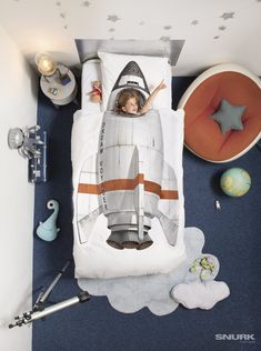 a child's bed with a toy rocket on it