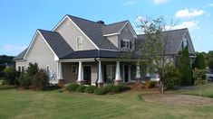 a gray house with white trim and black roof