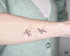 a woman's arm with two small turtles on the left side of her arm