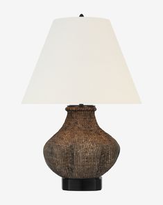 a lamp that is sitting on top of a table next to a white light shade