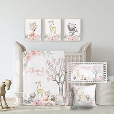 a baby crib with pink flowers and deers on the wall next to it