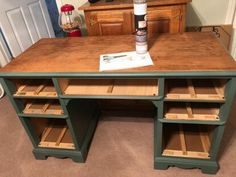 a wooden desk with drawers and a bottle on top in a room next to a dresser