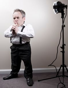 a man standing in front of a camera with his hands together