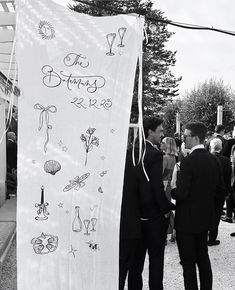 two men standing next to each other in front of a banner with writing on it