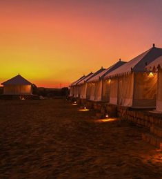 a row of tents sitting on top of a sandy beach