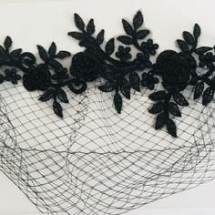 a piece of art that is made out of wire and black lace with flowers on it