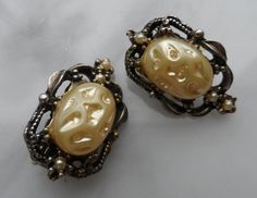 These wonderful earrings feature large faux baroque pearls made of resin or plastic, and they are set in a lovely very light, champagne gold tone finish metal with ornate details and three tiny faux seed pearls.  They clip securely.  They are unsigned but very much in the Selini Selro style.  This set is in very nice condition, and would make an outstanding addition to a vintage  jewelry collection. Antique Gold Clip-on Earrings For Party, Vintage Gold Pearl Clip-on Earrings, Baroque Pearl Earrings For Party, Victorian Gold Clip-on Earrings For Party, Victorian Style Gold Clip-on Earrings For Party, Party Clip-on Pearl Earrings, Seed Pearl, Champagne Gold, Baroque Pearls