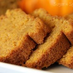 several pieces of bread sitting on top of a white plate next to some oranges