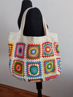 a white crocheted bag sitting on top of a mannequin head