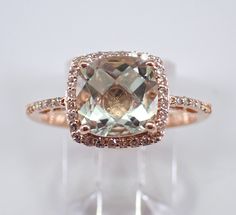 14K Rose Gold Diamond and Green Amethyst Halo Engagement Ring. This ring is set with one genuine Cushion Cut Green Amethyst (Prasiolite) in the center and forty natural Round Brilliant Diamonds. These diamonds are H color, SI1 clarity and weigh a total of .25 carat. The Green Amethyst is a pale green color, measures 8 X 8 mm and weighs 2 carats. This ring is 14KT Rose Gold, weighs 3.0 grams and is a finger size 7, which is resizable free of charge (please inquire about sizing with the finger size you need). The ring will be accompanied by an appraisal by a GIA Certified Diamond Grader with the retail replacement value of $1,465.00. I will ship this ring promptly in a gift box. Green Amethyst Wedding Rings With Gemstone Accents, Green Amethyst Rings With Gemstone Accents For Wedding, Elegant Cushion Cut Gemstones For Wedding, Elegant Amethyst Wedding Ring With Vs Clarity, Elegant Green Amethyst Ring With Accent Stones, Elegant Green Amethyst Ring For Formal Occasions, Elegant Green Amethyst Ring As A Gift, Elegant Green Amethyst Ring For Wedding, Elegant Green Amethyst Ring For Gift